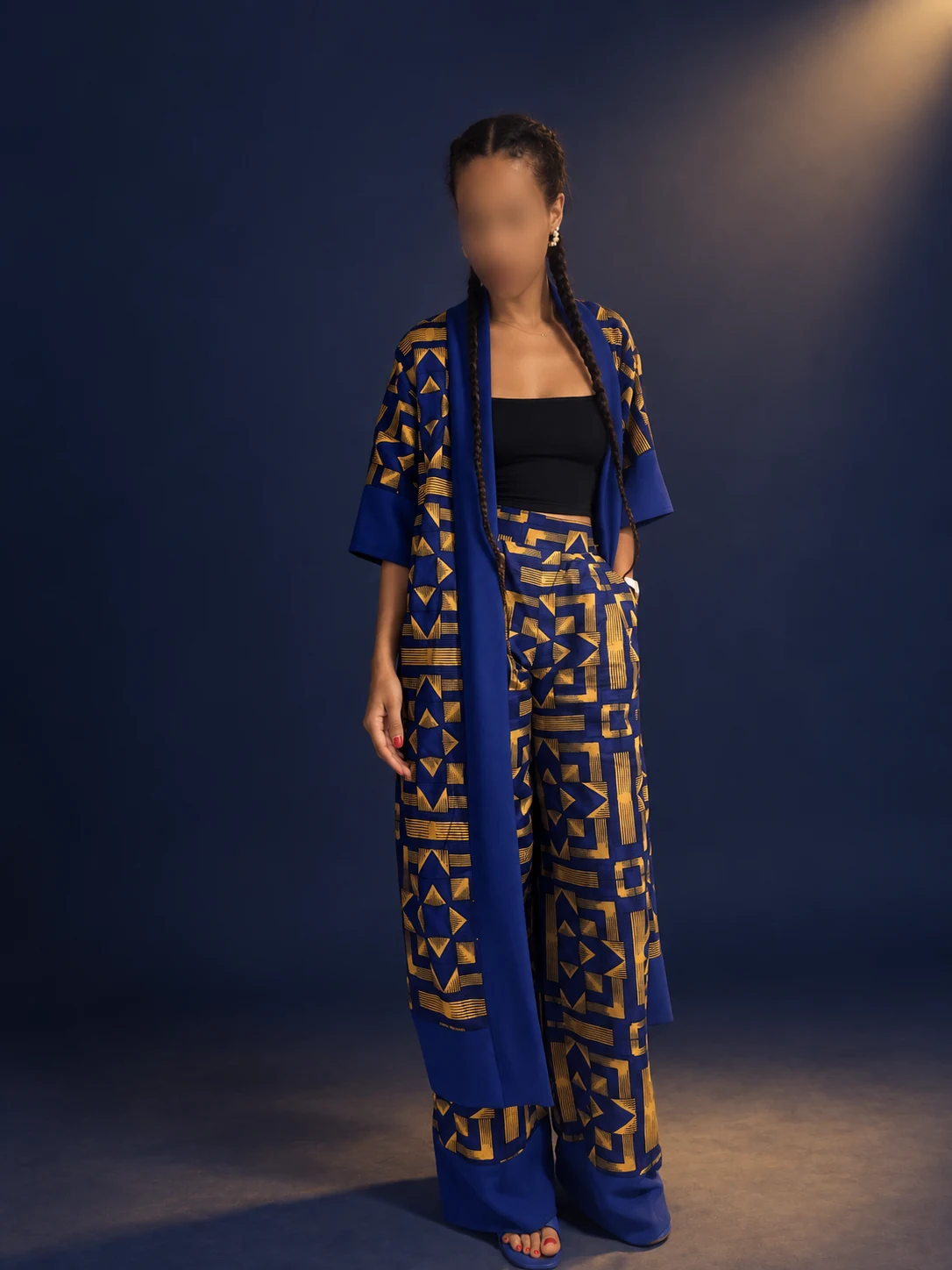 Ensemble veste et pantalon bleu et or à motifs géométriques, visage flouté
